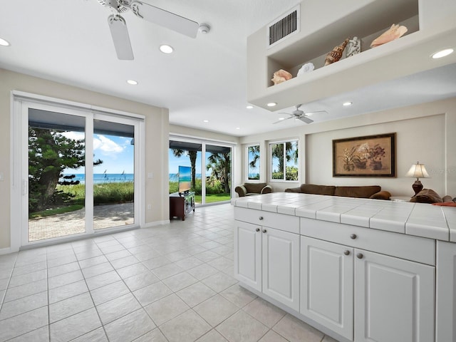 kitchen featuring tile countertops, white cabinetry, and light tile patterned flooring