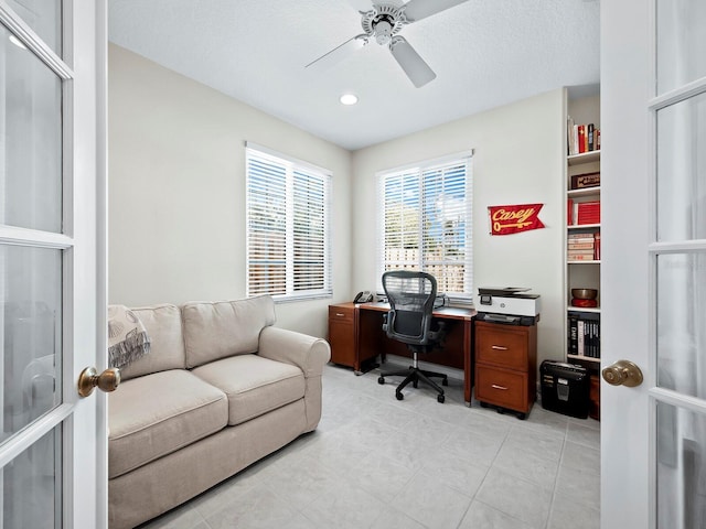 tiled office space featuring ceiling fan