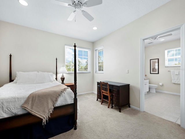 bedroom featuring ceiling fan, light carpet, and connected bathroom