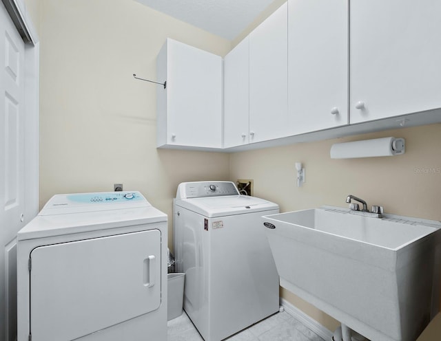 washroom featuring cabinets, sink, and washing machine and clothes dryer