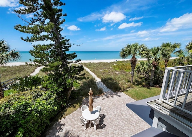 view of patio / terrace with a water view and a beach view