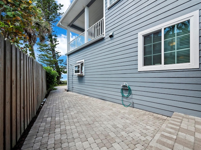 view of side of property featuring a patio and a balcony