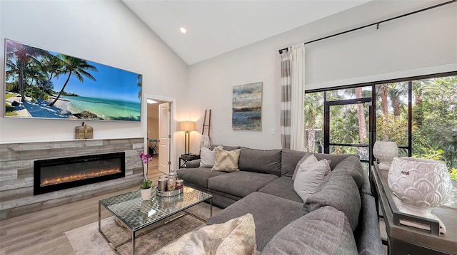 living room featuring high vaulted ceiling and light wood-type flooring