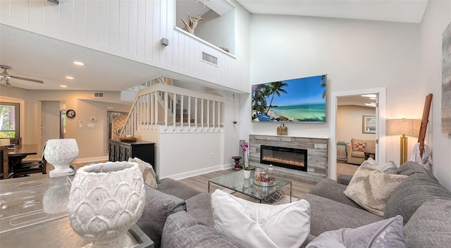 living room featuring a high ceiling, hardwood / wood-style flooring, and ceiling fan