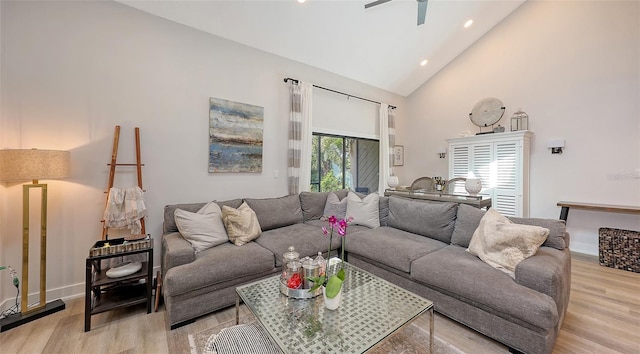 living room featuring light hardwood / wood-style floors, high vaulted ceiling, and ceiling fan