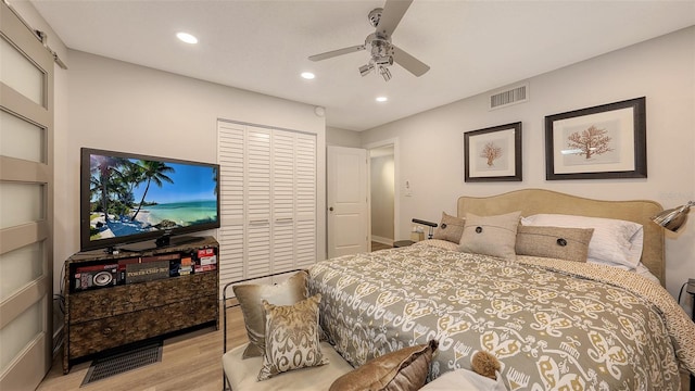 bedroom featuring ceiling fan, a closet, and light wood-type flooring