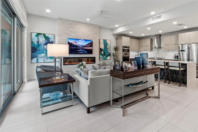 living room featuring a stone fireplace and sink