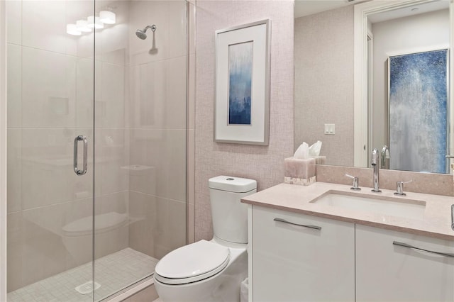 bathroom featuring a shower with door, vanity, and toilet