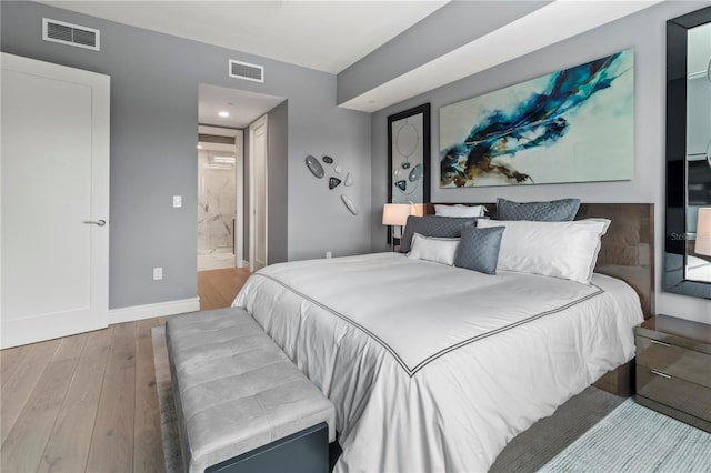 bedroom with light hardwood / wood-style flooring and ensuite bathroom