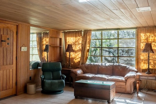 living area featuring wood walls, light tile patterned flooring, and wooden ceiling