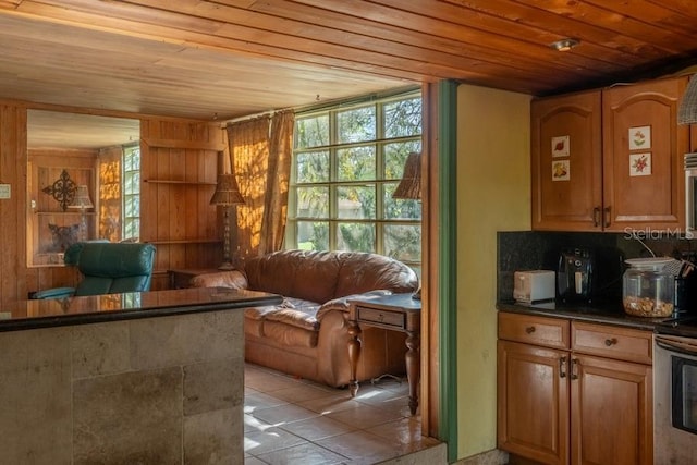 interior space featuring light tile patterned floors, backsplash, and wooden ceiling