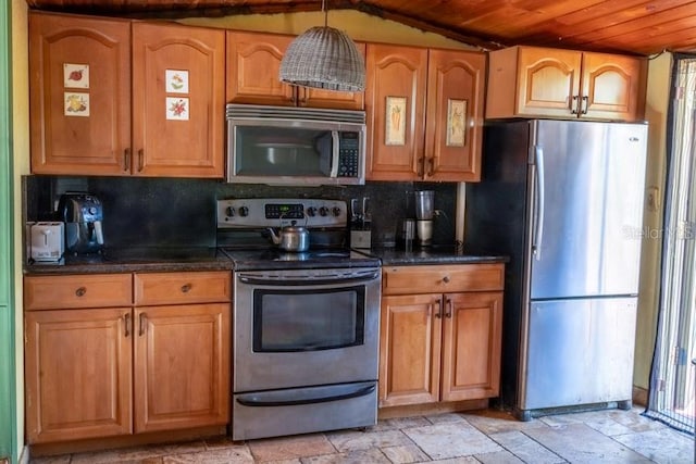 kitchen with decorative backsplash, lofted ceiling, stainless steel appliances, and hanging light fixtures