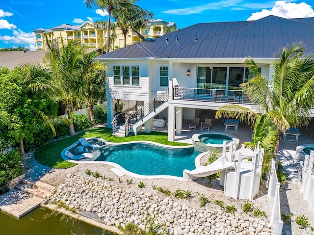 rear view of house featuring a pool with hot tub and a patio