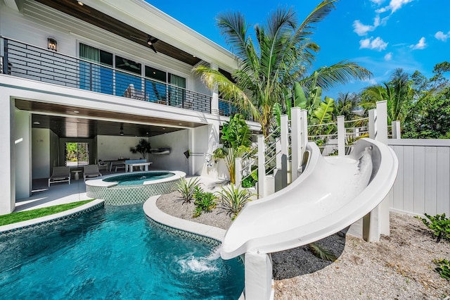 view of swimming pool featuring an in ground hot tub, a patio, and a water slide