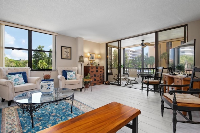 living room featuring floor to ceiling windows, a textured ceiling, a wealth of natural light, and ceiling fan