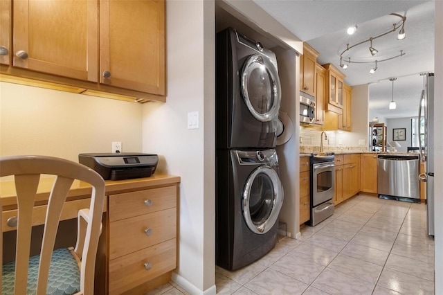 washroom with light tile patterned floors and stacked washer / dryer