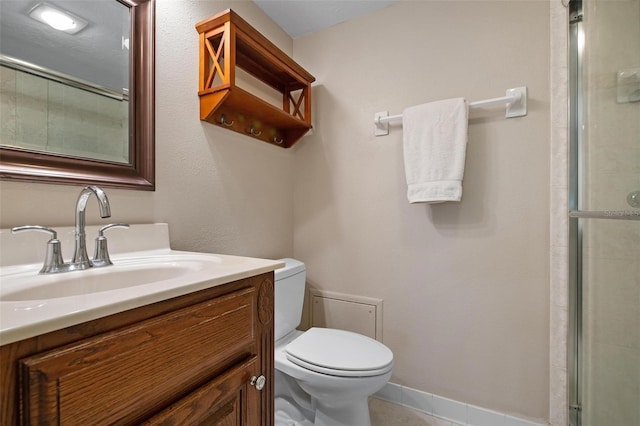 bathroom with tile patterned floors, vanity, toilet, and a shower with shower door