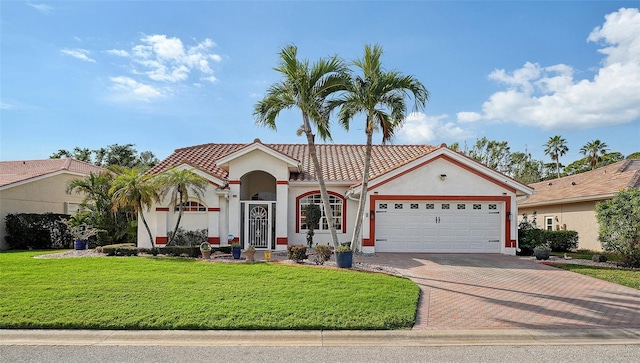 mediterranean / spanish home featuring a front yard and a garage