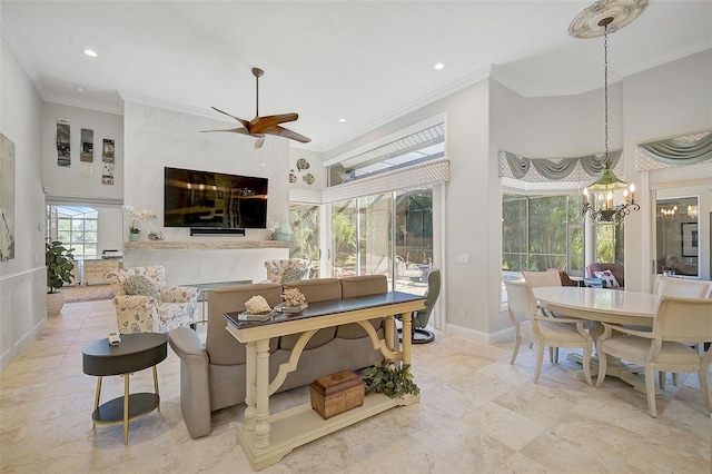 living room with ceiling fan with notable chandelier and crown molding