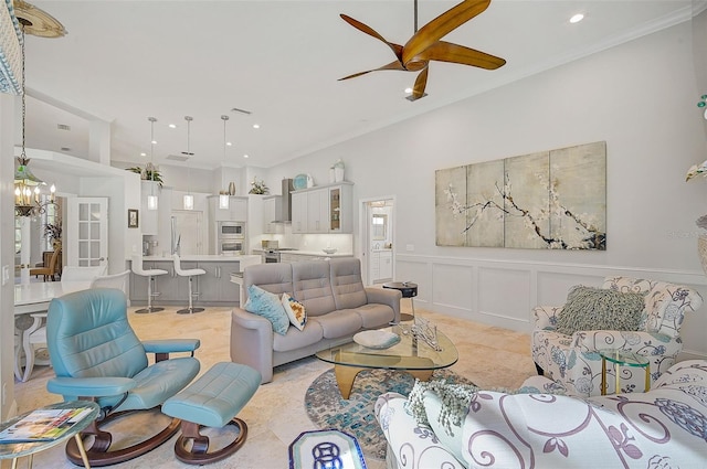 living room featuring ceiling fan with notable chandelier and ornamental molding