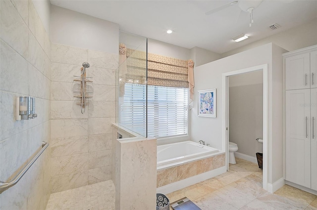 bathroom featuring ceiling fan, toilet, and plus walk in shower