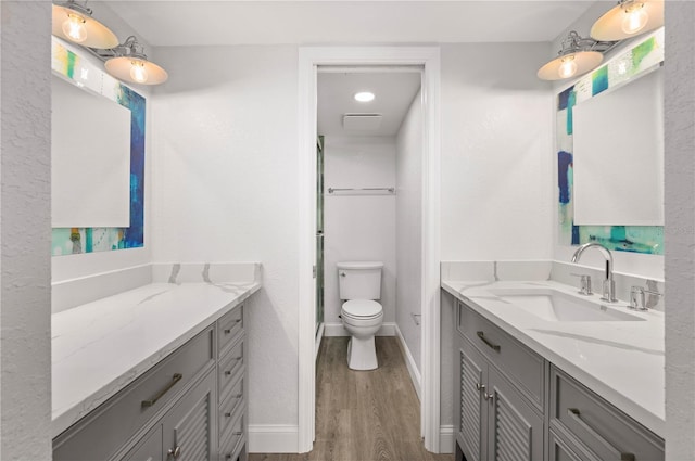 full bath featuring vanity, wood finished floors, toilet, and baseboards