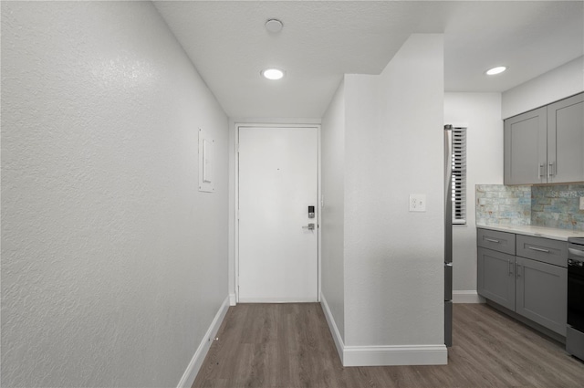 hallway featuring light wood-type flooring and baseboards