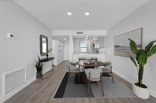 dining room featuring light wood-style flooring, recessed lighting, visible vents, and baseboards