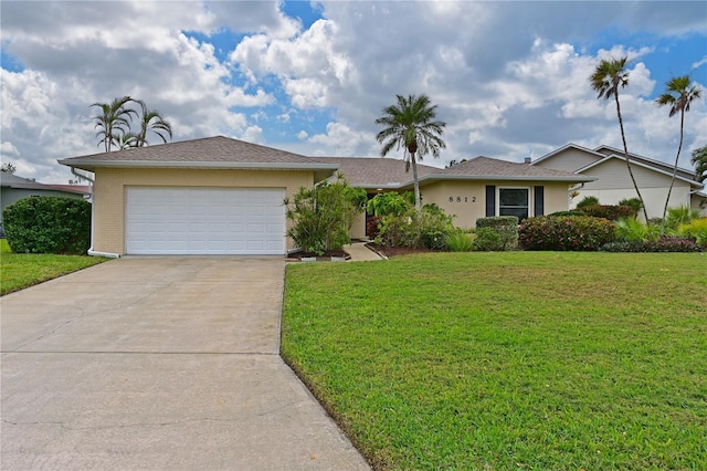 single story home with a garage, concrete driveway, a front lawn, and stucco siding