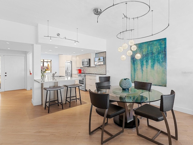 dining room featuring light wood-type flooring and sink