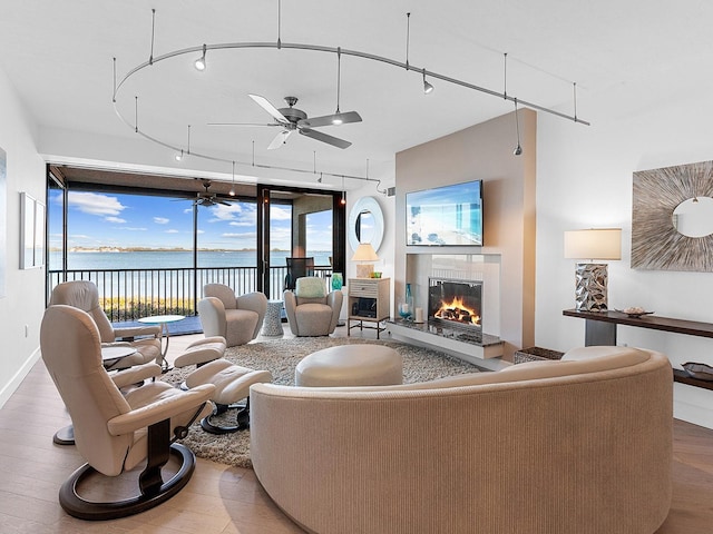 living room with ceiling fan, rail lighting, and hardwood / wood-style flooring