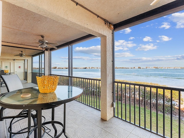 sunroom with ceiling fan, a water view, and a healthy amount of sunlight