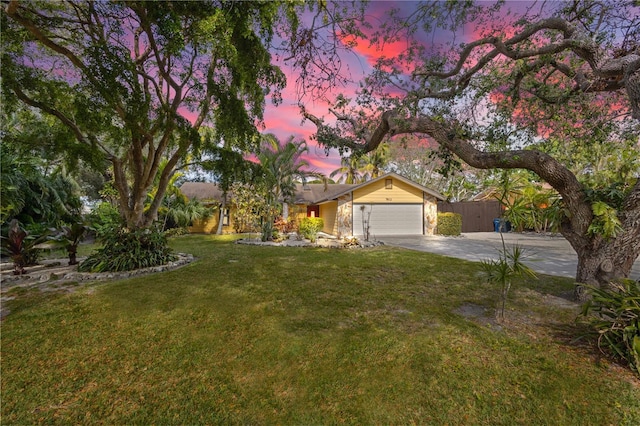 single story home featuring a garage and a lawn