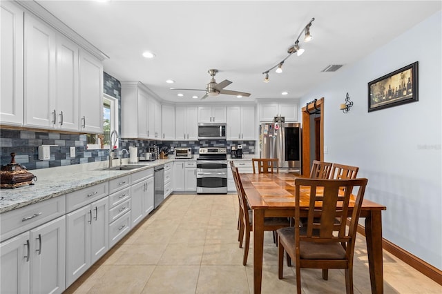 kitchen featuring light stone countertops, appliances with stainless steel finishes, sink, and white cabinets