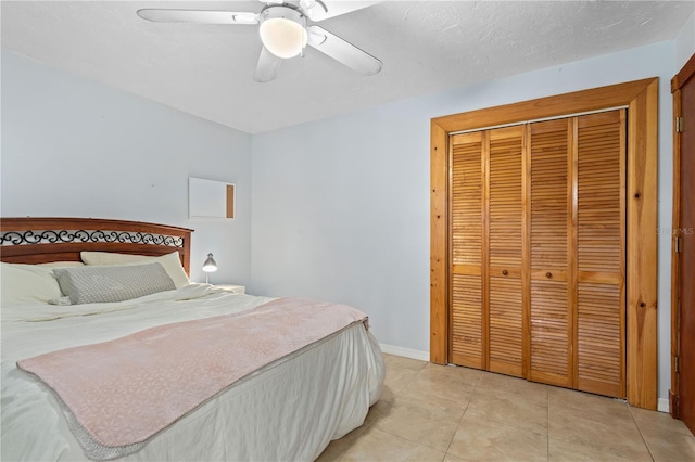 tiled bedroom featuring ceiling fan and a closet