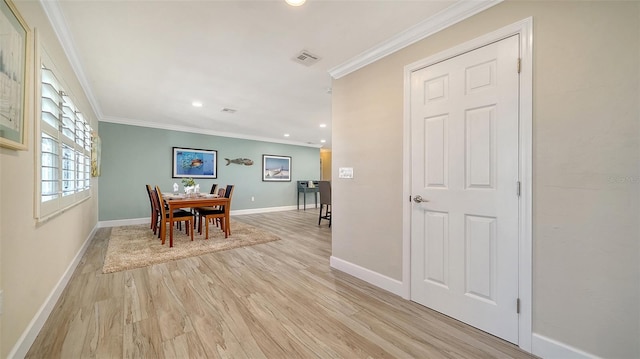 dining room featuring crown molding and light hardwood / wood-style flooring