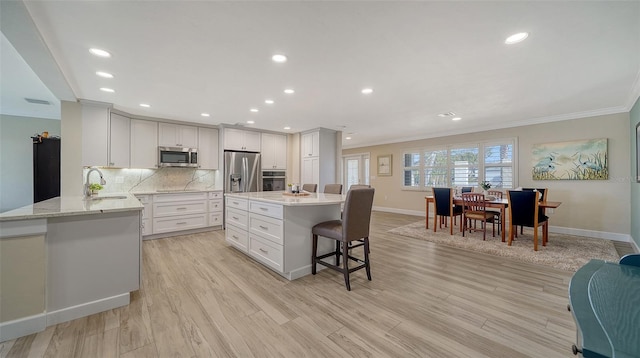 kitchen featuring sink, white cabinets, decorative backsplash, kitchen peninsula, and stainless steel appliances