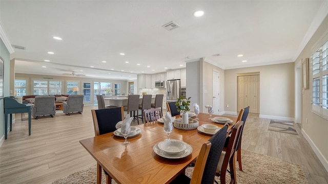 dining room featuring crown molding and light wood-type flooring