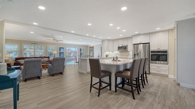 dining space with ornamental molding, ceiling fan, and light hardwood / wood-style floors