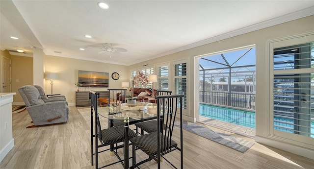 dining area with ceiling fan, ornamental molding, and light hardwood / wood-style floors