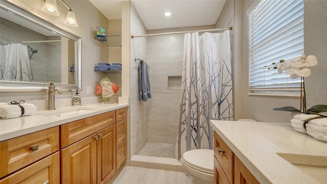 bathroom featuring vanity, toilet, and walk in shower