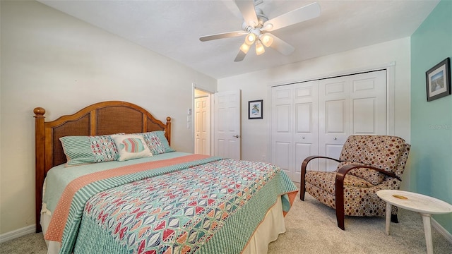 bedroom featuring light colored carpet, ceiling fan, and a closet