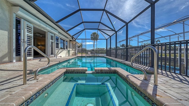 view of pool featuring a lanai, a patio area, and an in ground hot tub