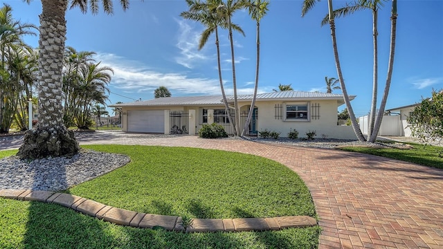 single story home with a garage and a front lawn