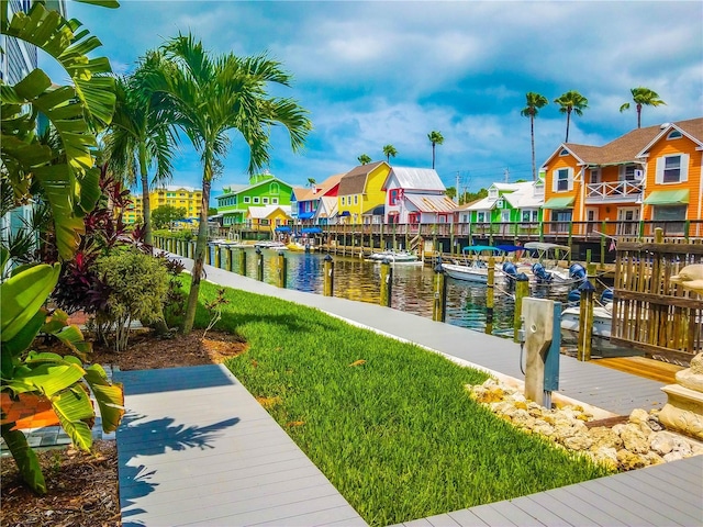 view of dock with a yard and a water view