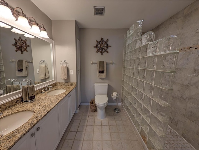 bathroom with tile patterned floors, toilet, vanity, and walk in shower