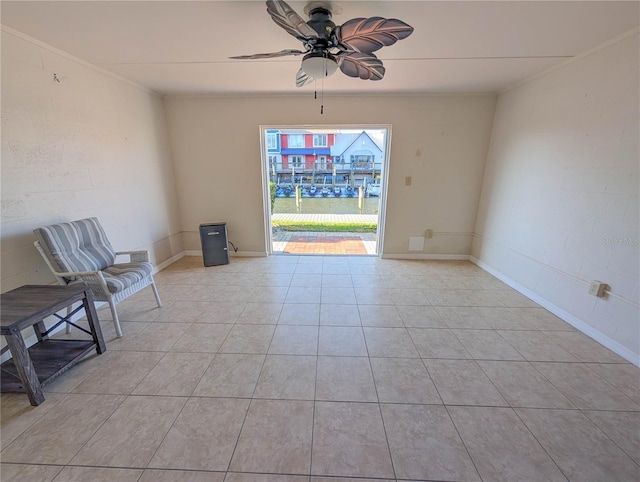 unfurnished room featuring ceiling fan, crown molding, and light tile patterned floors