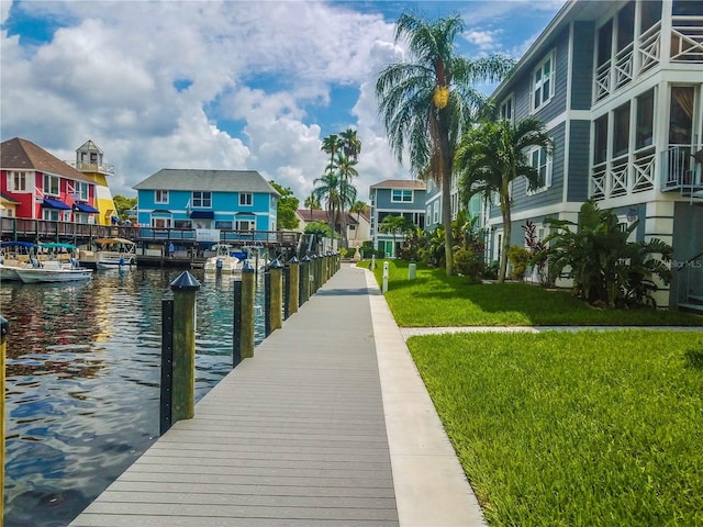 dock area with a lawn and a water view