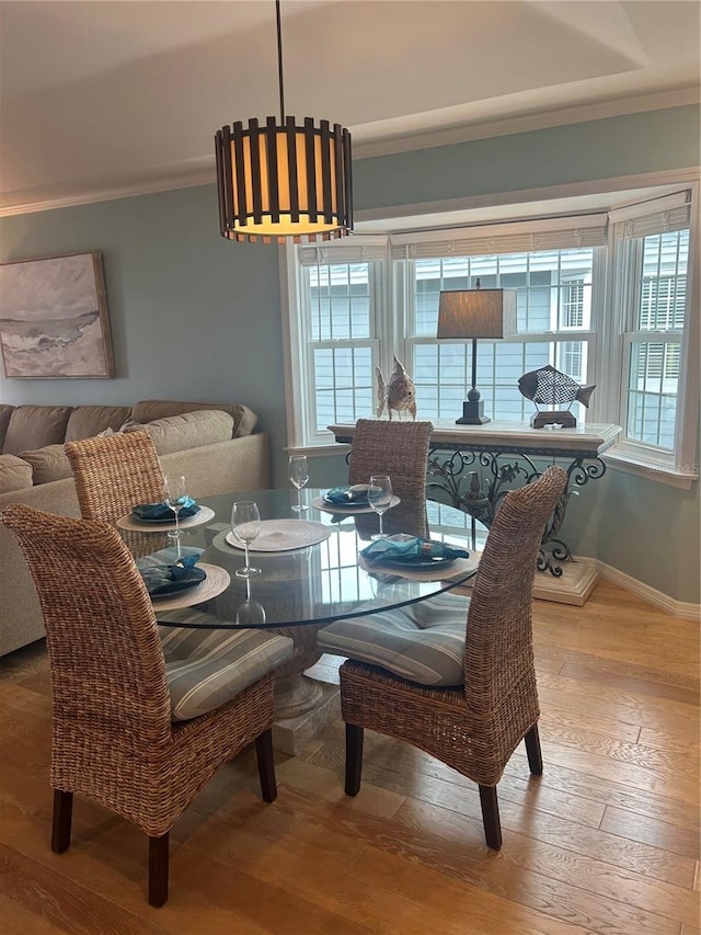 dining room with hardwood / wood-style flooring and ornamental molding