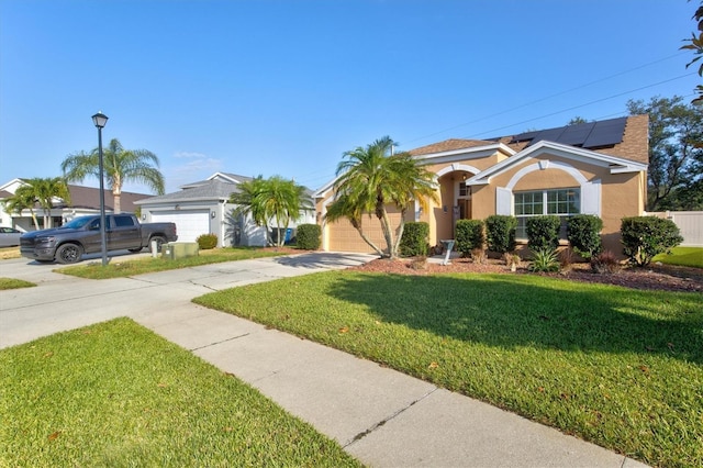 ranch-style home featuring solar panels, a garage, and a front lawn